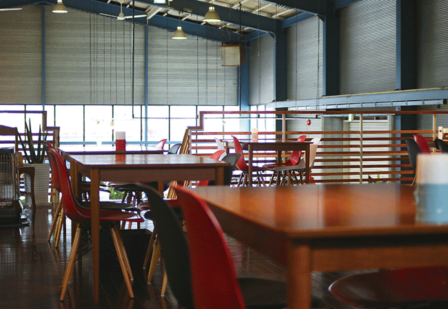 LITTLE CROWN Cafe�i���g���N���E���J�t�F�j�̃e�[�u���Ȃ̑��ɃJ�E���^�[������B�J�E���^�[�z���ɂ̓I�[�v���L�b�`�����L����B