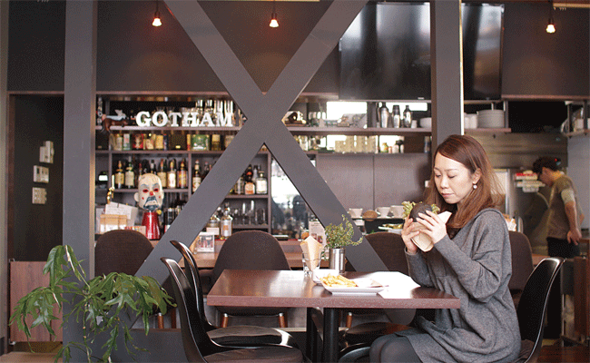 GOTHAM DINER.�i�S�b�T���_�C�i�[�j�̃e�[�u���Ȃ̂ق��A�C�P�����X�^�b�t�Ɖ�b���ł���I�[�v���L�b�`���O�̃J�E���^�[�������ɐl�C�B